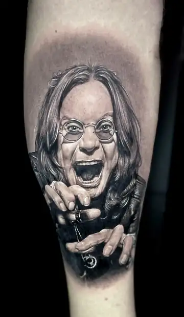 Retrato de Ozzy Osbourne, tatuagem em realismo preto e cinza no antebraço