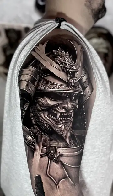 Máscara de samurai com dragão no elmo, tatuagem em realismo preto e cinza no ombro